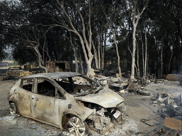 A burned car is seen in front of a wildfire ravaged home Tuesday, July 31, 2018, in Lakeport, Calif.